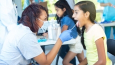 Healthcare worker swabbing a person's tongue