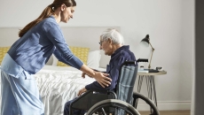 Healthcare worker helping an elderly patient in a wheelchair