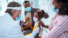 Young child getting a vaccine with their parents
