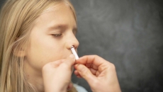 Hands administer inhaler to child