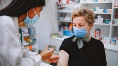 Pharmacist administers a vaccine to an elderly patient