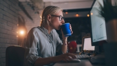 Worker with coffee cup at computer