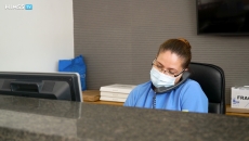 Healthcare worker in mask at a desk using phone
