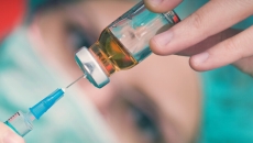Close-up of a healthcare worker extracting a vaccine from a vile