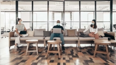 Open office with workers in masks on a couch