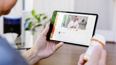 Person with pill bottle talking to doctor on a tablet