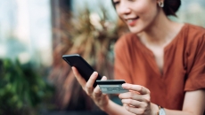 Person using smartphone with credit card