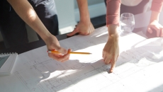 Hands pointing over blueprints