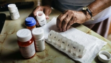 Hands sorting through a pill box