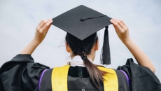 Graduate in robes holding cap