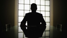 Silhouette of person looking out of boardroom window