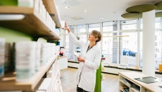 Pharmacist at shelves of pill bottles