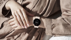 One hand reaches for smartwatch on opposite wrist