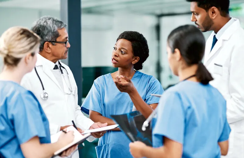 A group of medical professionals stands, talking