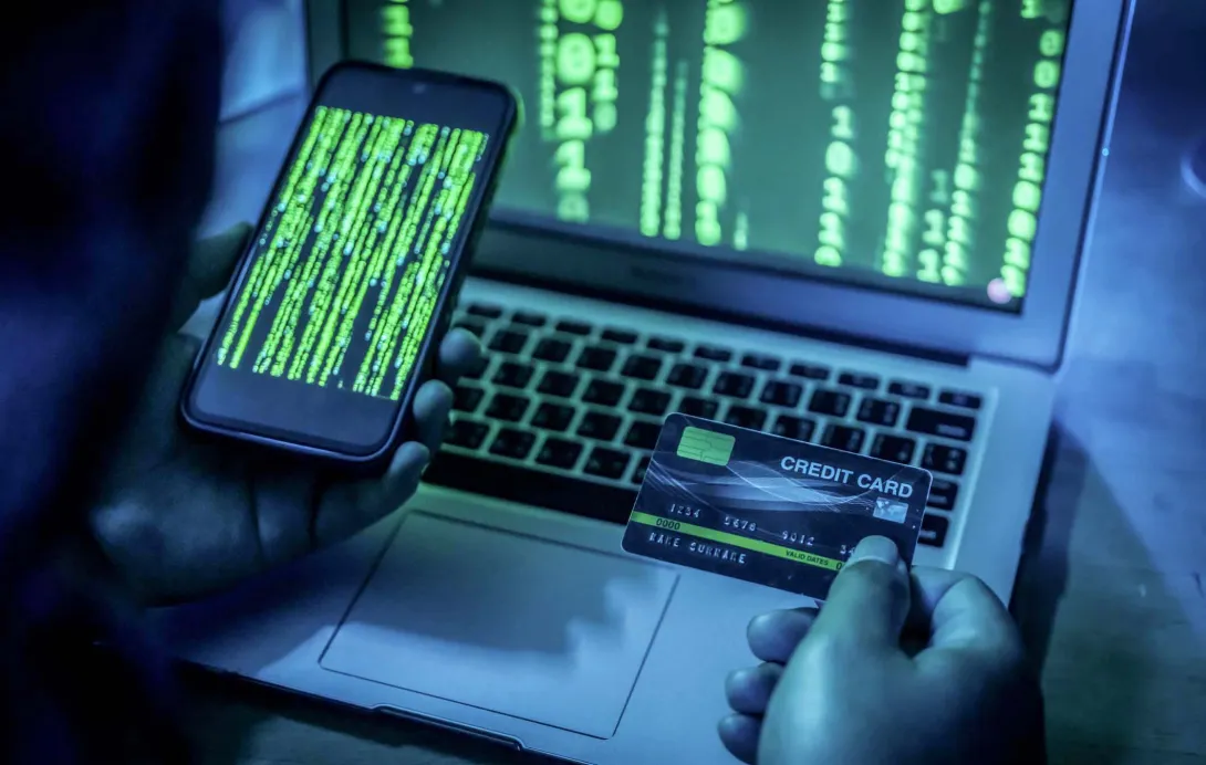 Person on smartphone has credit card out and is also looking at a laptop screen Person on smartphone has credit card out and is also looking at a laptop screen