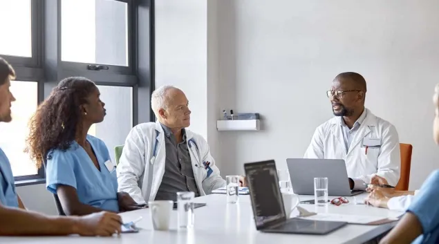 Clinicians at a board table Clinicians at a board table