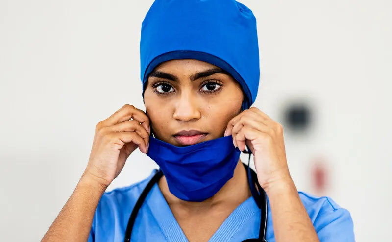 A healthcare professional wears a mask. A healthcare professional wears a mask.