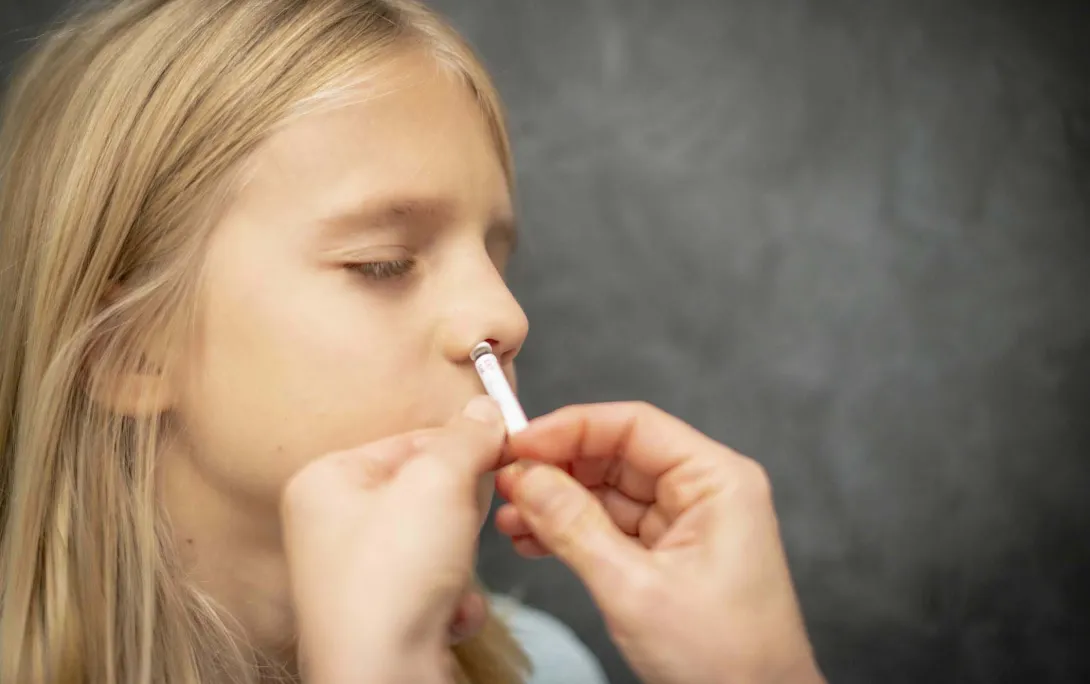 Hands administer inhaler to child Hands administer inhaler to child