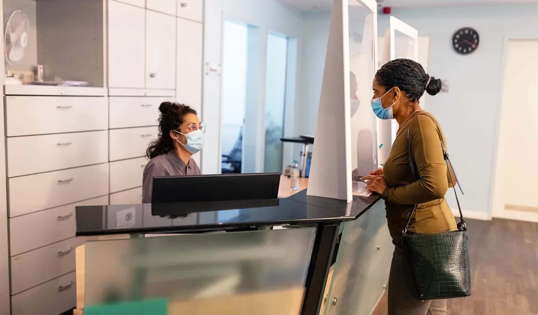 Patient at doctor's office reception desk