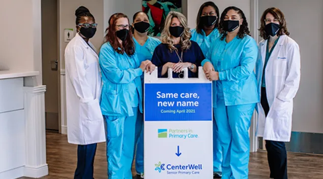 People behind a CenterWell standing sign