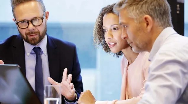 Business meeting with three at a table Business meeting with three at a table