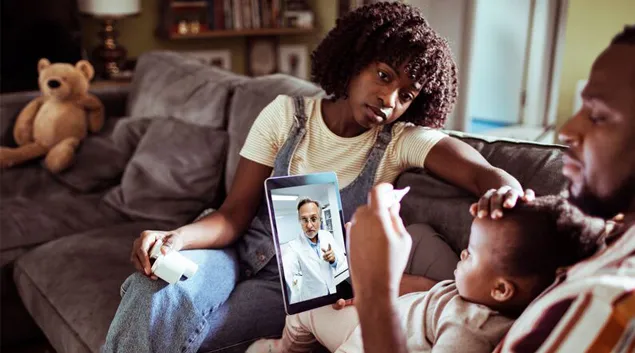 Parent and child with tablet showing healthcare professional