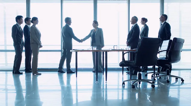 Businesspeople greet in a lobby