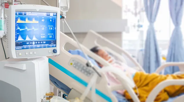 Patient in hospital bed with a monitor
