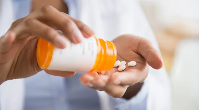 Hand dispensing pills from a bottle