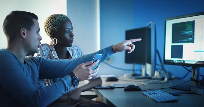 Workers pointing at a computer screen