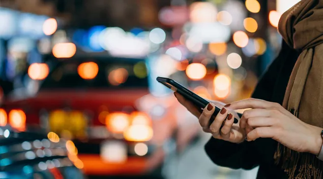 Person on city street looks at phone Person on city street looks at phone