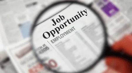 Magnifying glass over newspaper looking for a job
