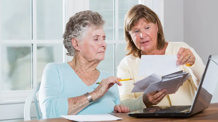 Worker helping senior patient with forms.
