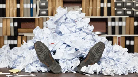 employee buried in paperwork
