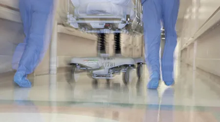 busy doctors pushing gurney