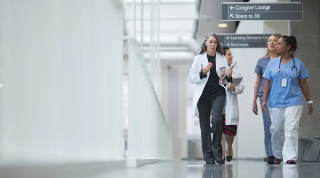 Clinicians walking down hospital corridor