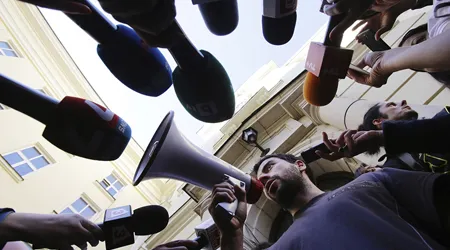 person using a megaphone into mircophones