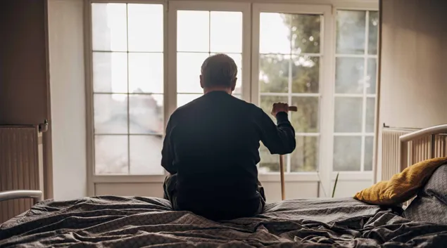 Silhouette of senior staring out nursing home window Silhouette of senior staring out nursing home window