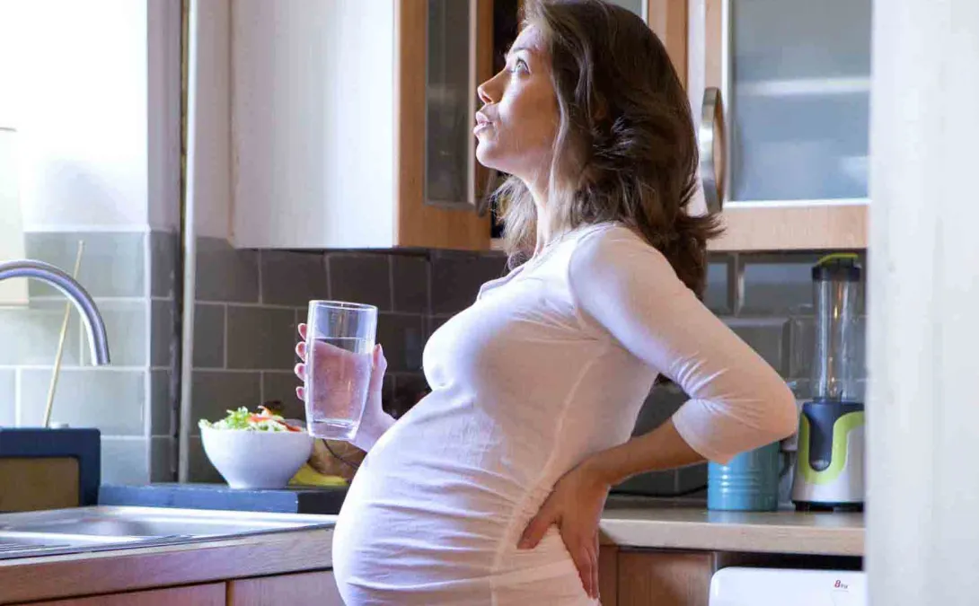 Pregnant woman holding glass of water