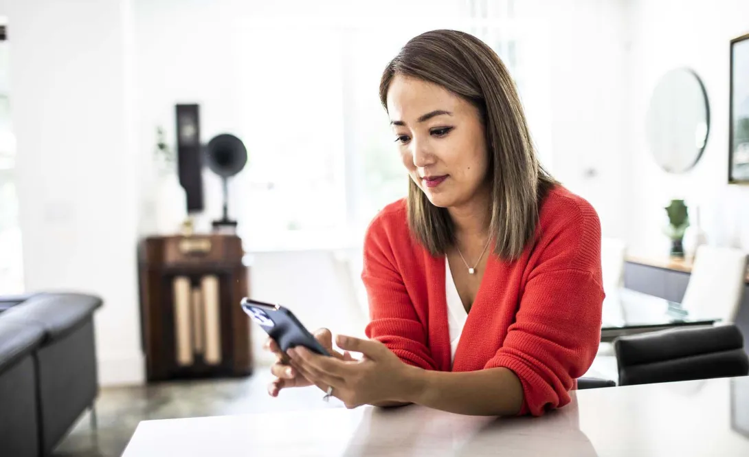 Person at table with smartphone