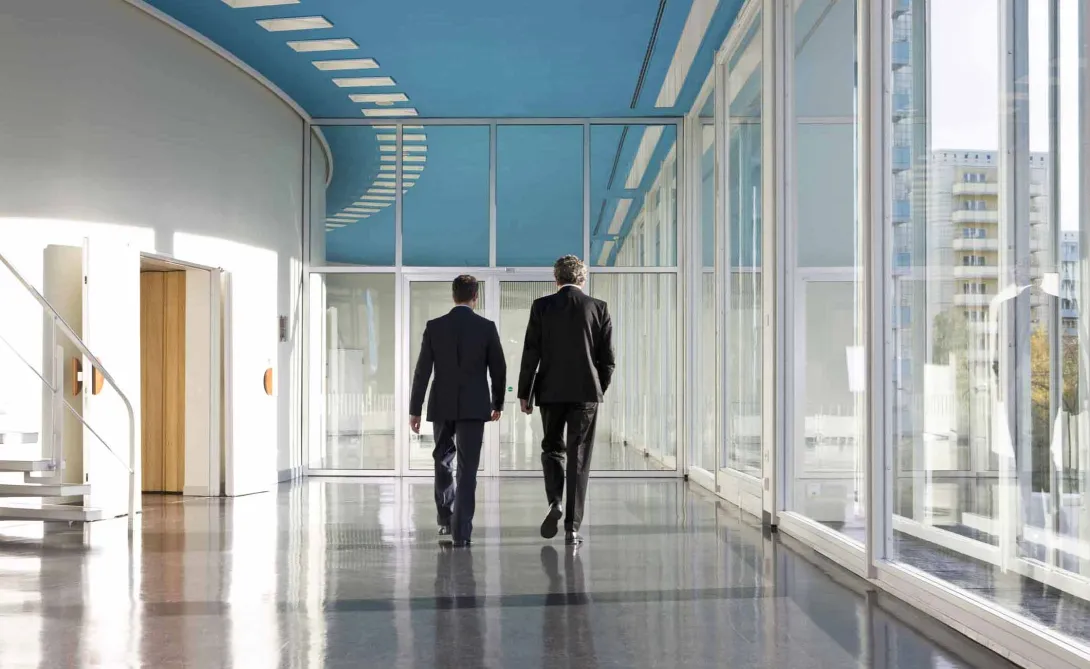 Business people in hospital hallway walking away