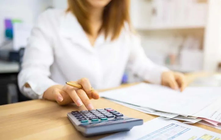 An accountant tallies numbers on a calculator.