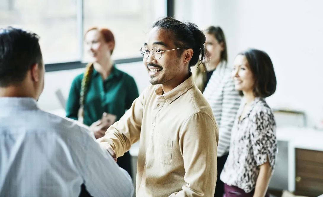 People greet in a sunny room. Photo: Thomas Barwick/Getty Images
