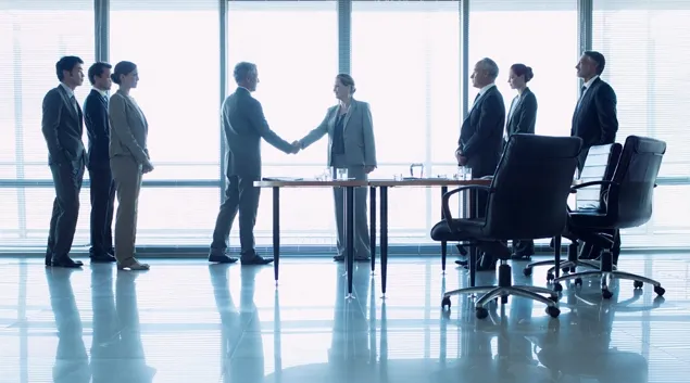 Businesspeople greet in lobby. Photo: Martin Barraud/Getty Images