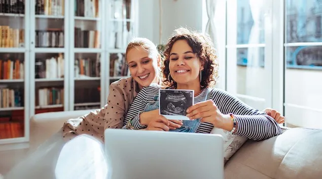 Couple showing ultrasound photo over video call