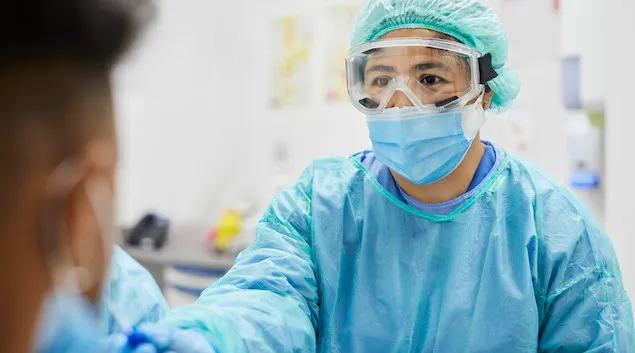 Doctor in PPE collecting a COVID-19 sample