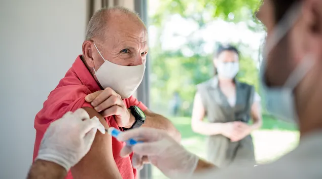 Person wearing a face mask getting a vaccine