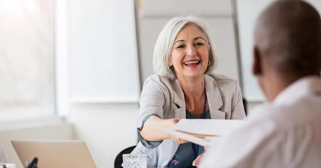 Hospital administrator handing document to doctor