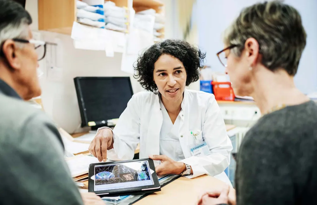 Doctor meets with a couple in office.