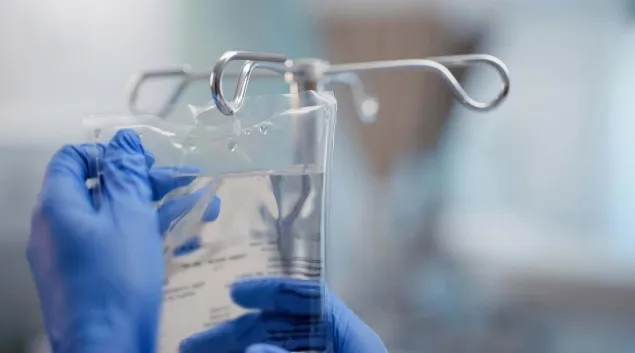 Hand holding an IV bag